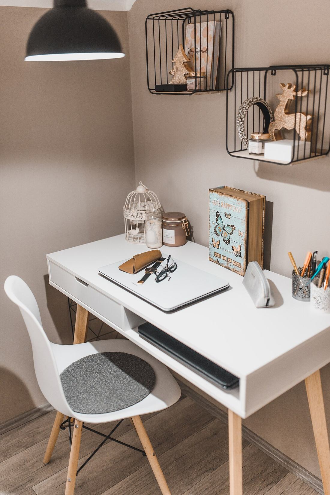 A white desk is arranged in a cozy room
