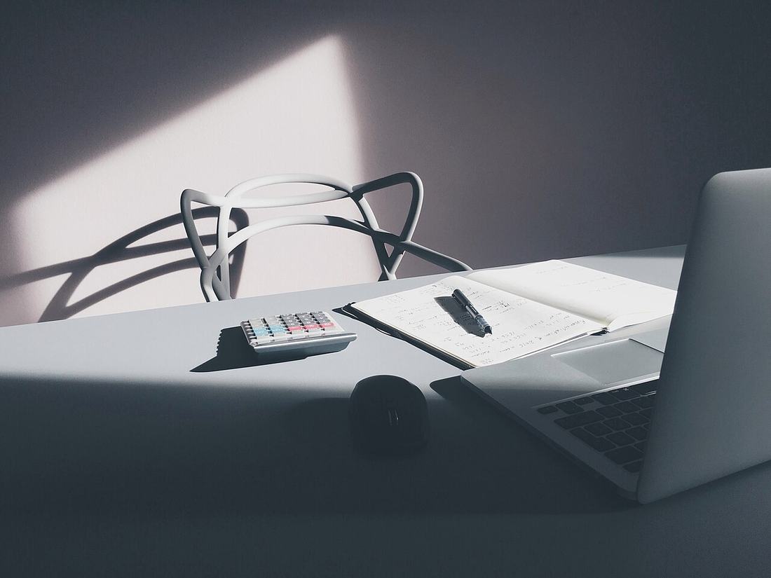 Desktop with laptop and calculator (Unsplash)